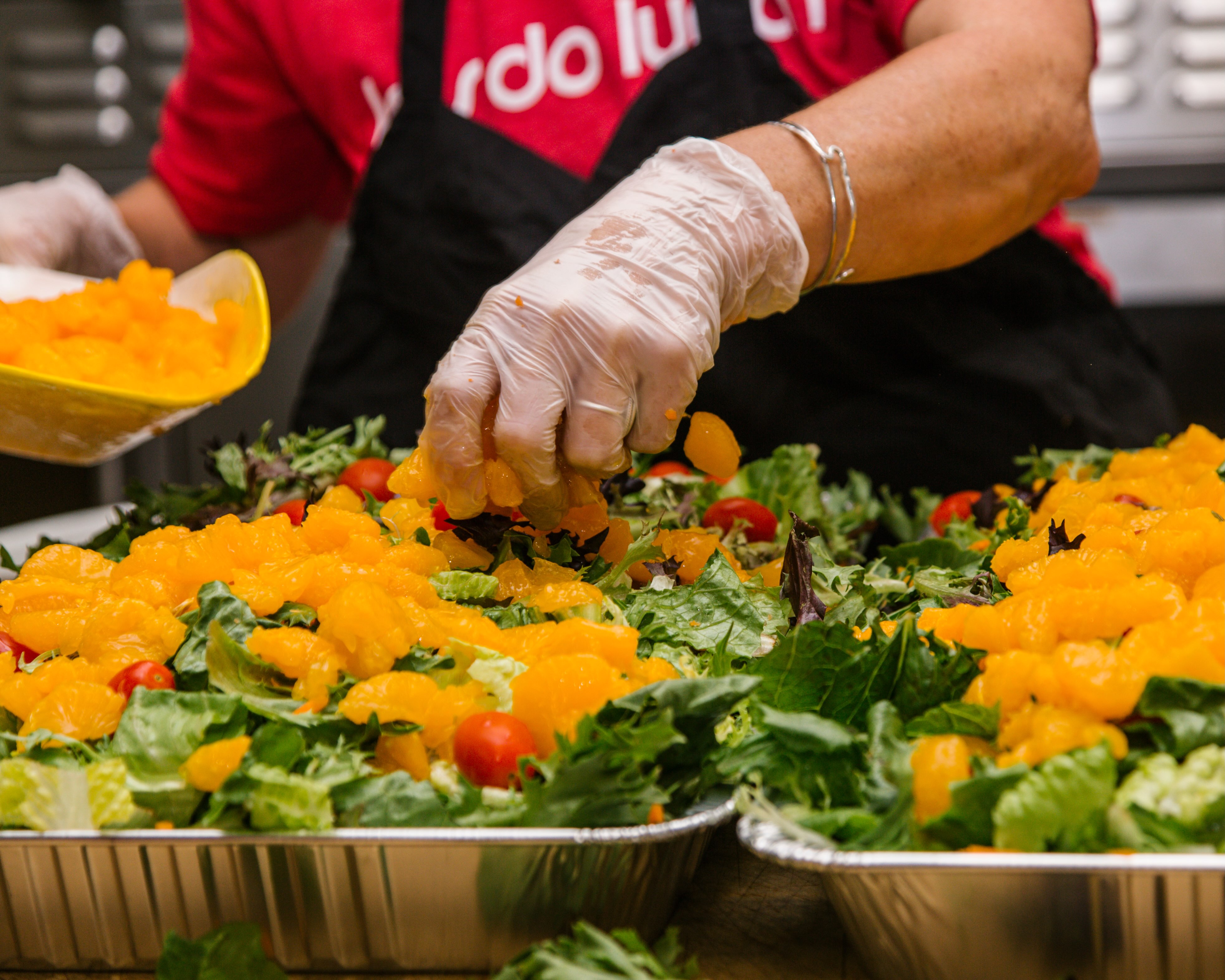 A Red Radish team member plating fresh salads in the kitchen